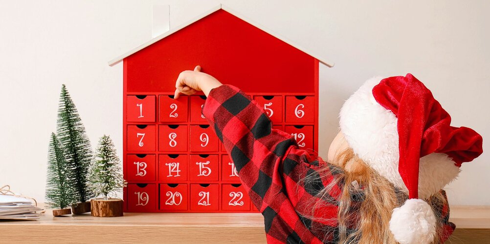 Adventskalender vor einem Kind mit einer Mütze. HEV_56271_47728.jpg